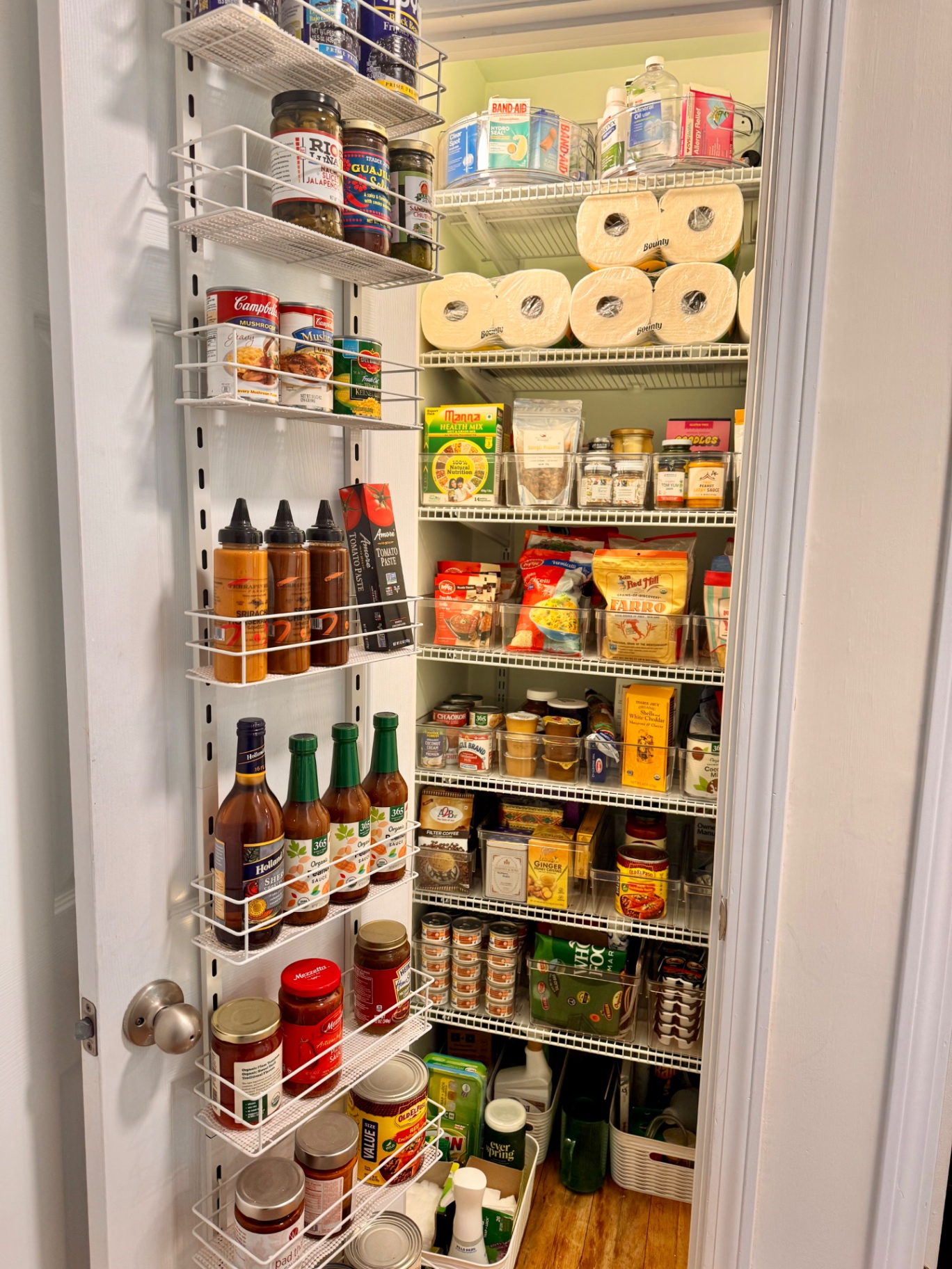 Full pantry organized with clear bins, door rack, and labeled categories.